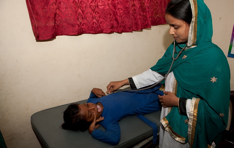 De dokter van de medical clinic bij het kamp onderzoekt Jannat Ara (10jr, tong tumor).