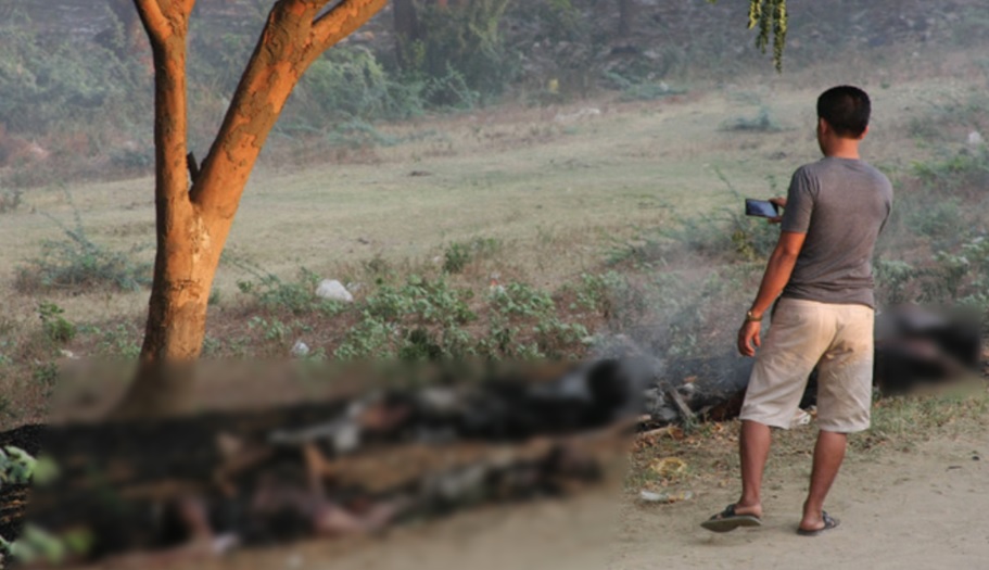Een voorbijganger maakt in maart 2013 foto's van de lichamen van levend verbrande moslims in Meiktila, Myanmar.